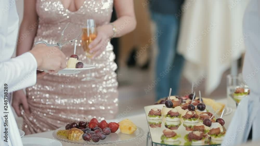 Waiter's hands put food in dish. Waiter puts desserts on a dish Waiter's hands put food in dish. Waiter puts desserts on a dish