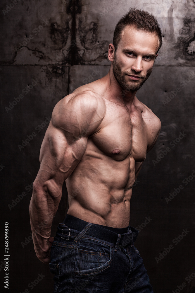 Fototapeta premium strong athletic man on dark grunge background