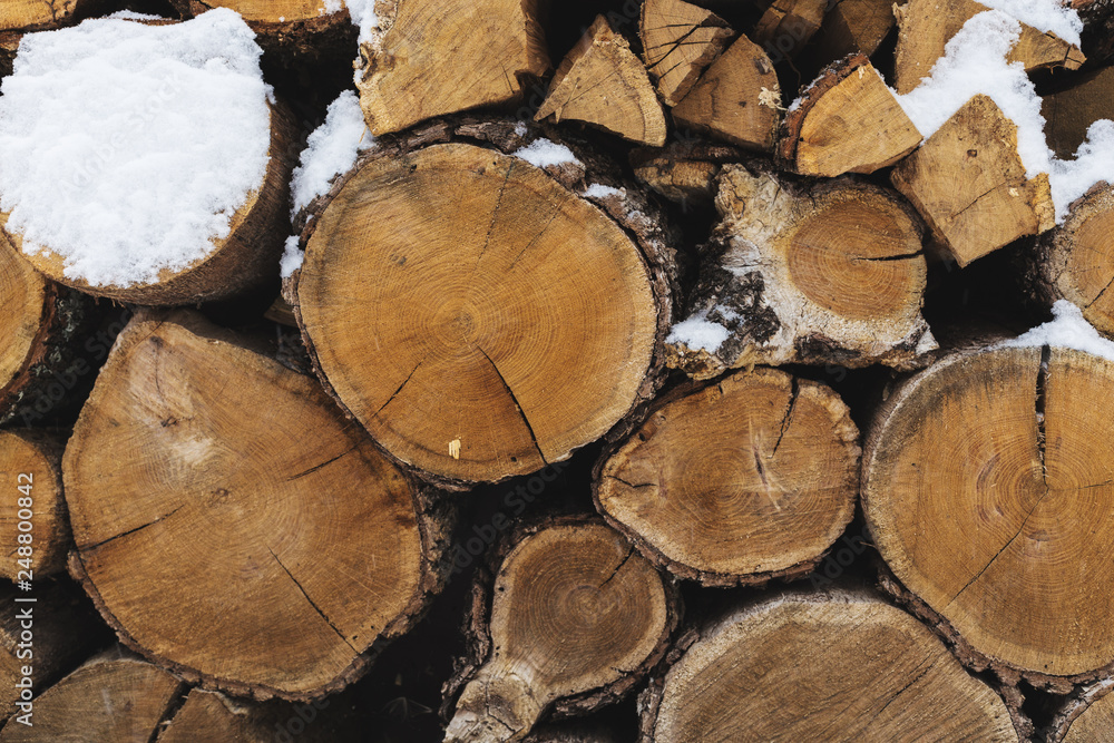 Chopped stock of firewood under snow on the street. Firewood for fireplace and bbq Chopped stock of firewood under snow on the street. Firewood for fireplace and bbq