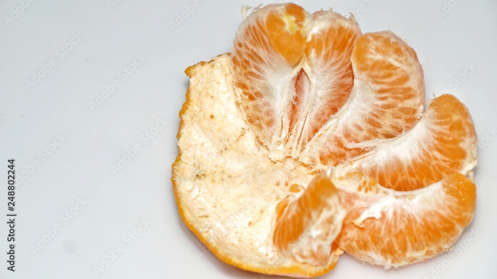 Ripe juicy peeled mandarin orange. isolated on white background. Selected focus. Close up. Ripe juicy peeled mandarin orange. isolated on white background. Selected focus. Close up.