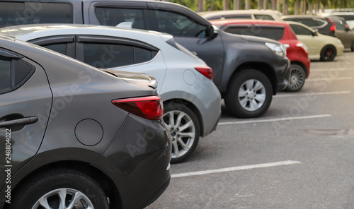 Closeup of back or rear side of brown car and other cars parking in parking area in twilight evening.  © Amphon