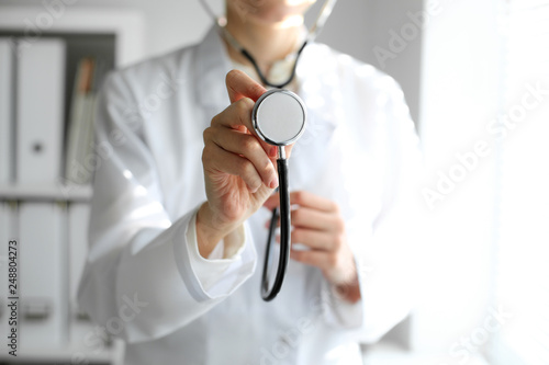 Doctor woman at work. Portrait of female physician using stethoscope. Medicine and healthcare concept