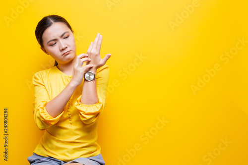Woman scratching her hands isolated over yellow background