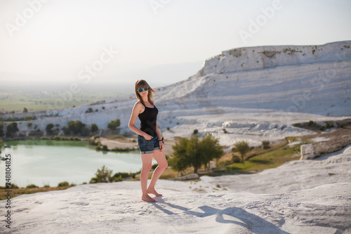 Natural travertine pools and terraces in Pamukkale. Cotton castle in southwestern Turkey, girl looking on travertine pools and terraces A woman in the pool of thermal springs and travertine
