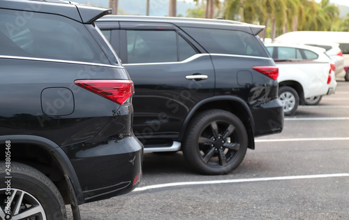 Closeup of back or rear side of black car and other cars parking in parking area with natural background.  © Amphon