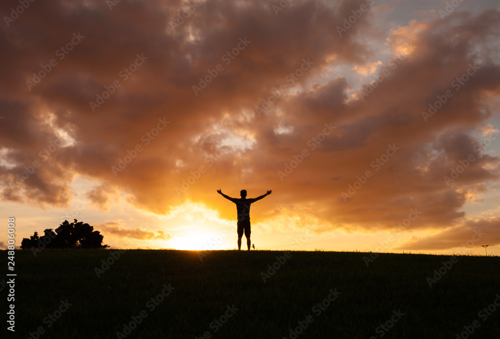 Man with open arms at sunset feeling happy and free