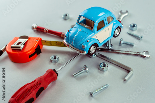 Fototapeta Naklejka Na Ścianę i Meble -  Closeup set of tools wrenches with blue toy car. Car repair concept.  - Image