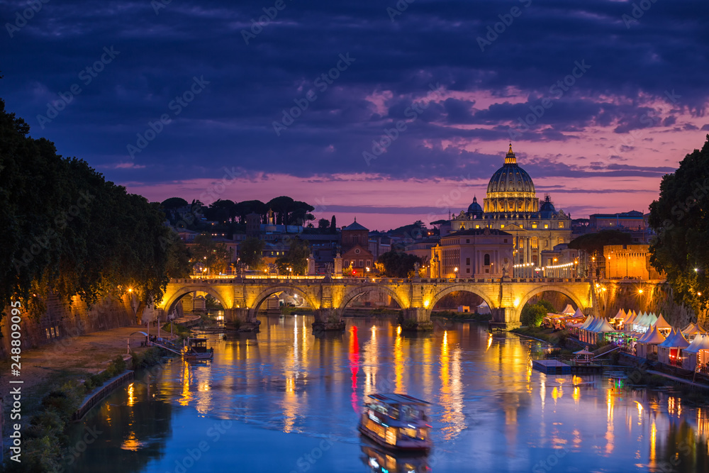 Night view of old Sant' Angelo Bridge  and St. Peter's cathedral in Vatican City Rome Italy.