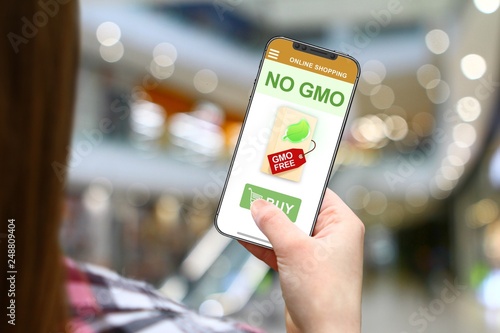 No GMO idea, girl with frameless phone on blurred mall background