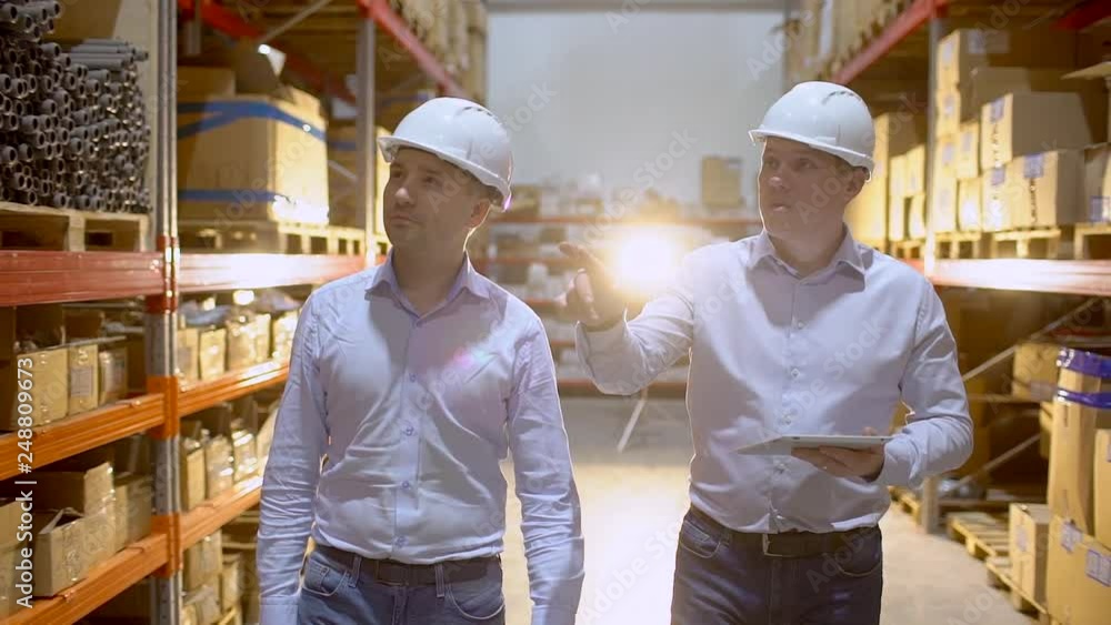employees male warehouse workers engineers in hard hat working in logistics center factory construction site, two engineers discussing work with tablet computer. architects businessman man engineer employees male warehouse workers engineers in hard hat working in logistics center factory construction site, two engineers discussing work with tablet computer. architects businessman man engineer