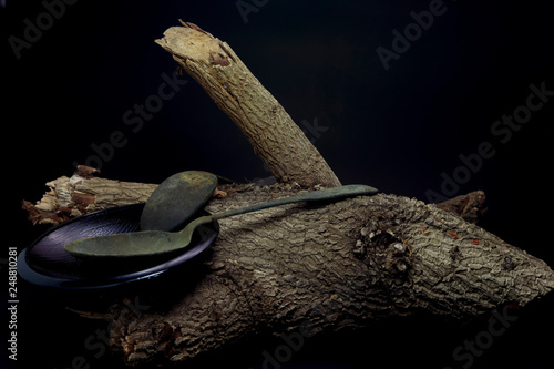 Spoon and dish on timber on black background for decoration.