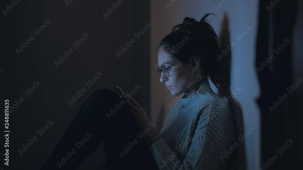 Medium shot - Beautiful woman in glasses and knitted sweater use smartphone at night. 4k. Medium shot - Beautiful woman in glasses and knitted sweater use smartphone at night. 4k.