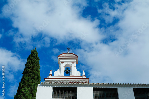 Bell-tower of a white church in Seville, Spain