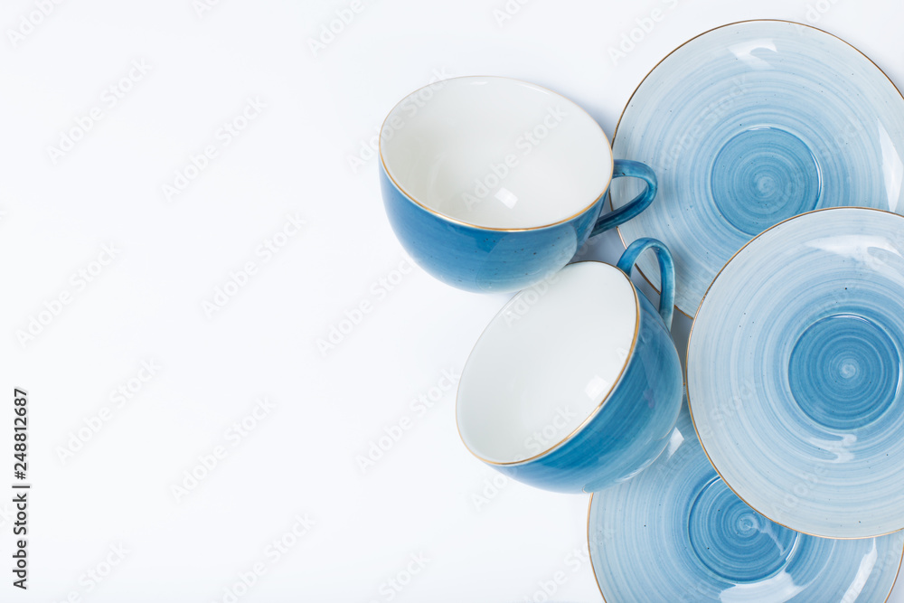 Clean dishes, coffee or tea set. Plenty of elegant porcelain cups and saucers at white background Clean dishes, coffee or tea set. Plenty of elegant porcelain cups and saucers at white background