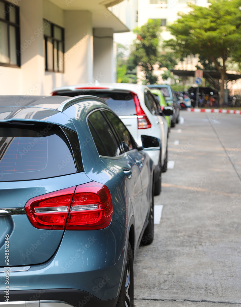 Closeup of rear or back side of blue car with  other cars parking in parking area. Vertical view.