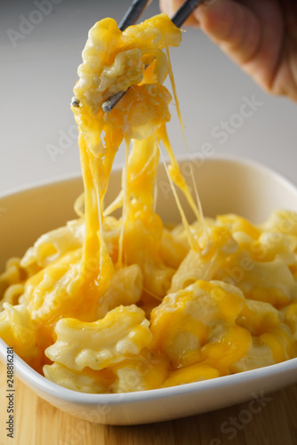 man eating mac and melted cheese with metal chopsticks