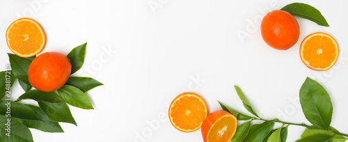 fresh, juicy oranges with green twigs lie on a white background