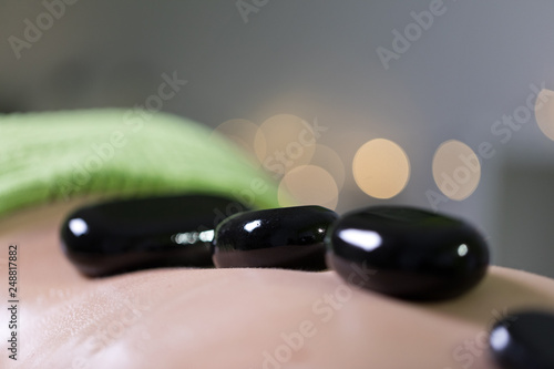 Woman in a day spa getting a hot stone treatment. Hot stone massage