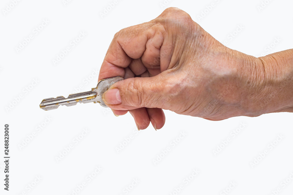 Senior woman's right hand holding key isolated on white background Senior woman's right hand holding key isolated on white background