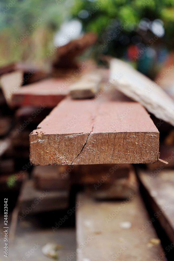 Flat wood piece closeup in wood with green forest background Flat wood piece closeup in wood with green forest background