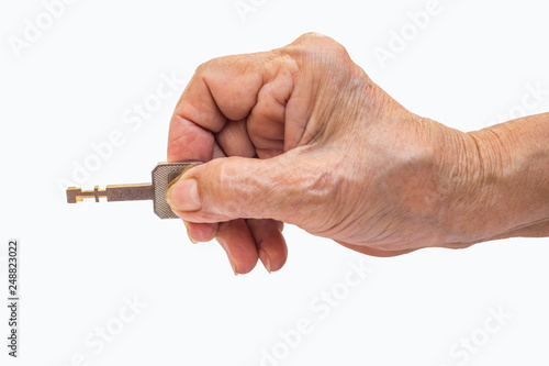 Senior woman's right hand holding key isolated on white background