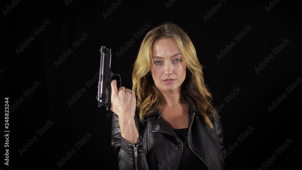Tough and sexy woman in a black leather jacket, holding a handgun. Tough and sexy woman in a black leather jacket, holding a handgun.