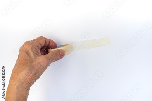 Senior woman's hands holdling and using  sticky tape isolated on white background