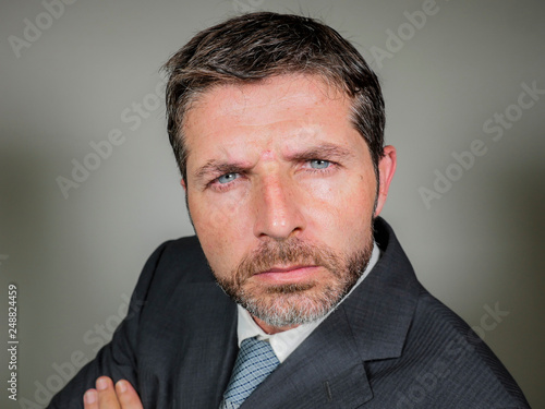 young handsome and attractive businessman in suit and tie looking serious and inquisitive posing bossy and cool as if wondering or listening to employee excuses