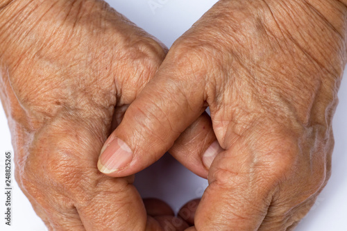 Senior woman's grasping her hands, wrinkled skin texture of blood in back of the hands on white background , Close up & Macro shot, Selective focus, Body part, Healthcare concept