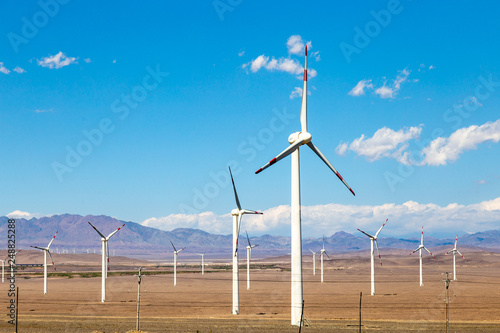 Aug 2017 – Xinjiang, China – The deserts of Xinjiang, the westernmost province of China, are full of Wind Turbine Power Plants. Here a Wind farm along the highway from Turpan to Urumqi