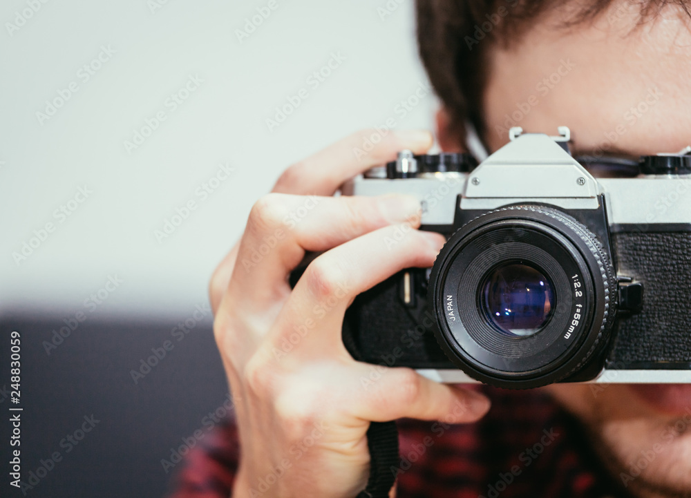 Young man is taking a picture with a vintage camera Young man is taking a picture with a vintage camera