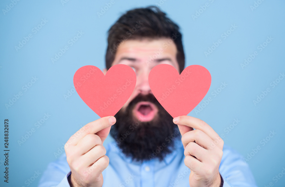 Love is amazing. Man bearded hipster with heart valentine card. Celebrate love. Guy attractive with beard and mustache in romantic mood. Feeling love. Dating and relations concept. Happy in love Love is amazing. Man bearded hipster with heart valentine card. Celebrate love. Guy attractive with beard and mustache in romantic mood. Feeling love. Dating and relations concept. Happy in love