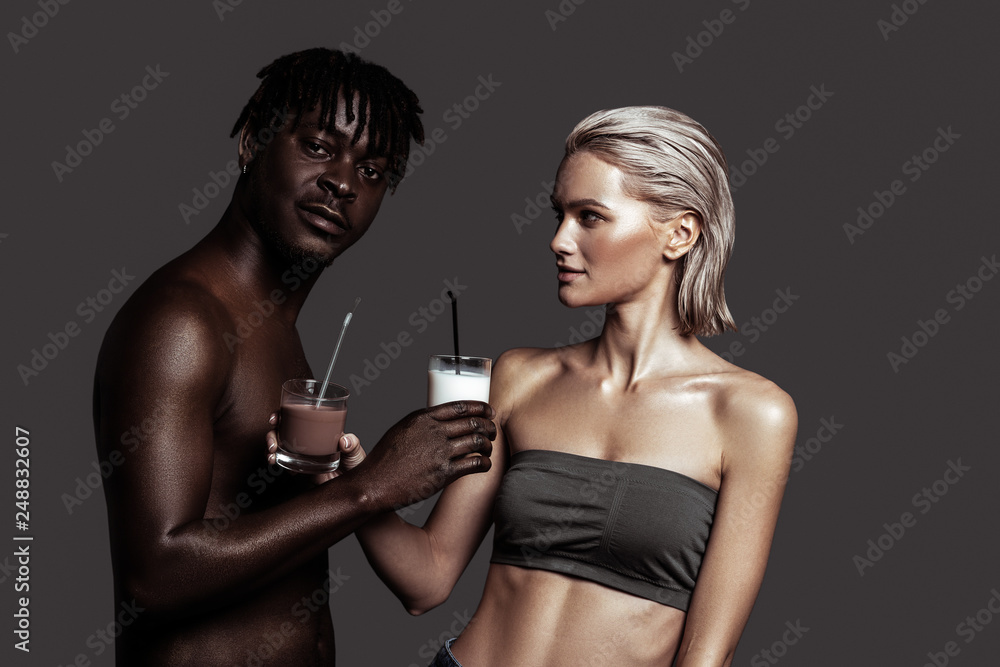 Model giving glass of chocolate drink to African-American boyfriend Model giving glass of chocolate drink to African-American boyfriend