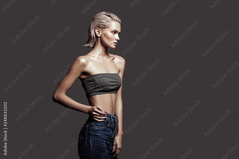 Slim blonde-haired model with bob cut wearing nice jeans Slim blonde-haired model with bob cut wearing nice jeans