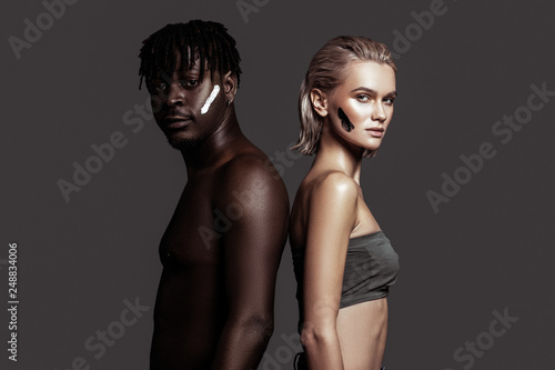 Slim model posing sideways near African-American man