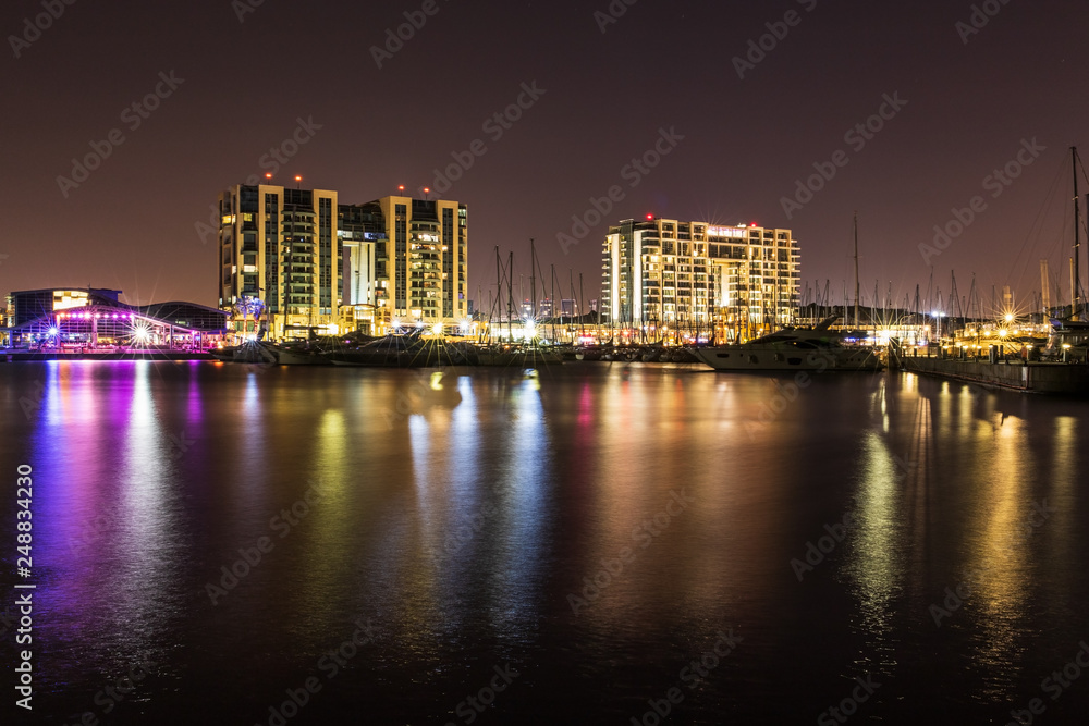 Night view of herzliya from the mediterranean marina with reflection