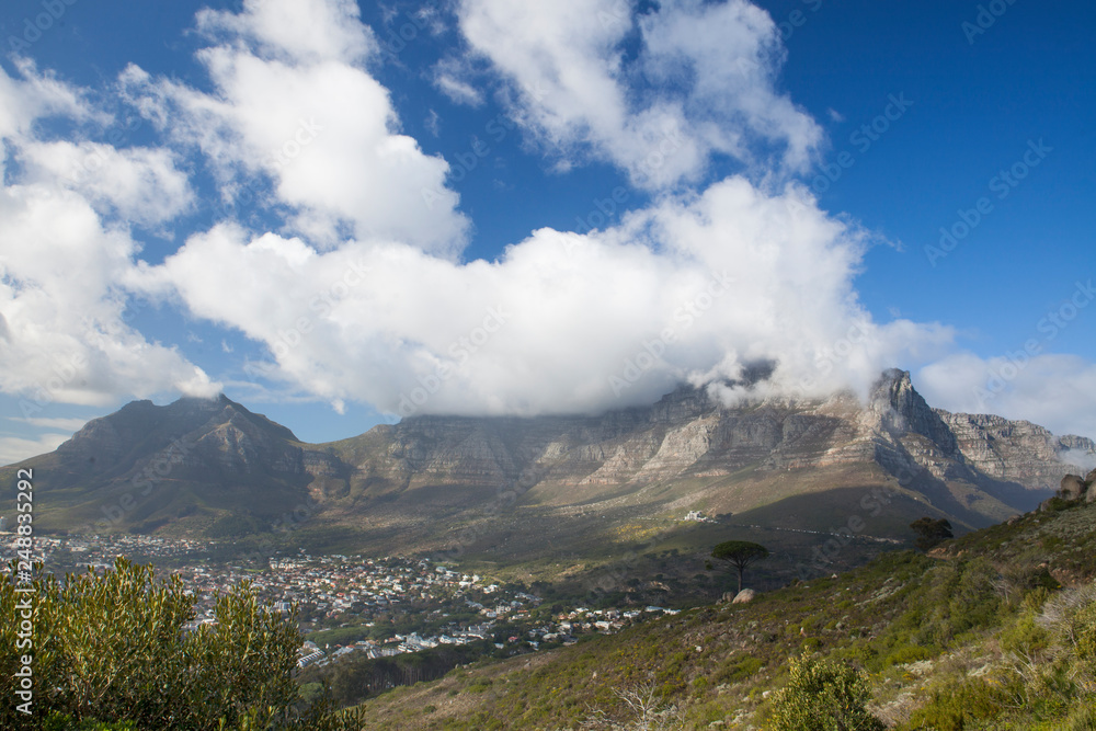 Clouds spilling over Table Mountain on a clear day, Cape Town, South Africa
