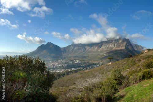 Clouds spilling over Table Mountain on a clear day, Cape Town, South Africa