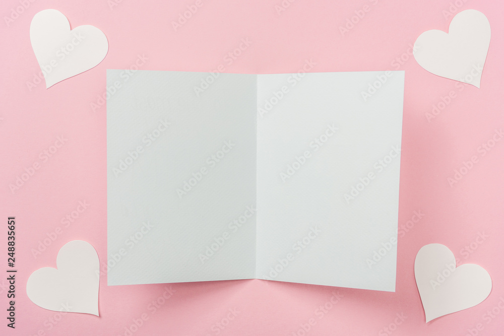blank greeting card and white paper hearts on pink background blank greeting card and white paper hearts on pink background