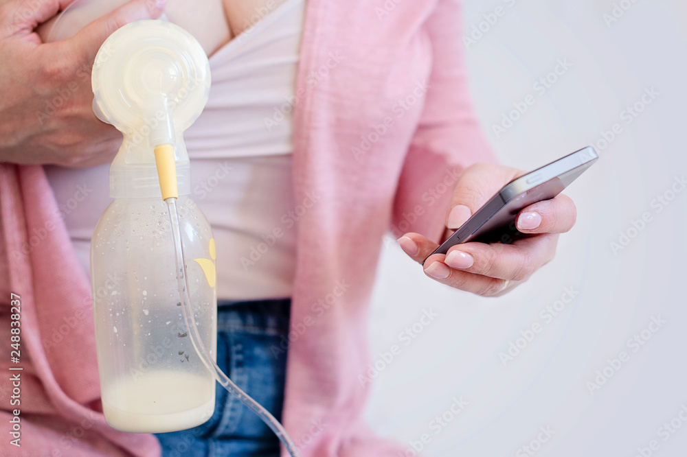 Mother is Using Single Electric Breast Milk Pump in One Hand and