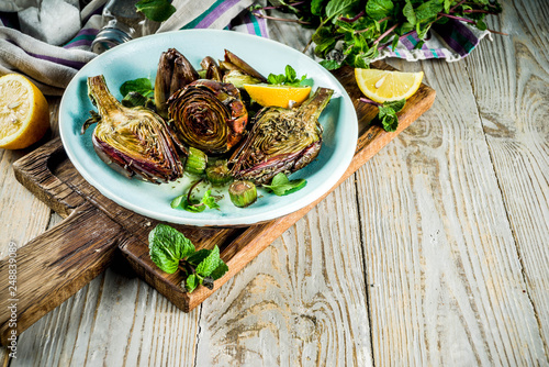 Cooked baked artichoke, alla romana, grilled artichoke flowers with olive oil, lemon, garlic, mint and spices. Copy space