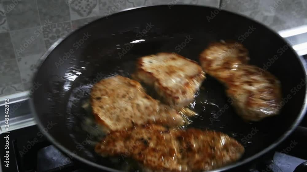 Girl shakes a griddle with grilled chops in slow motion. Girl shakes a griddle with grilled chops in slow motion.