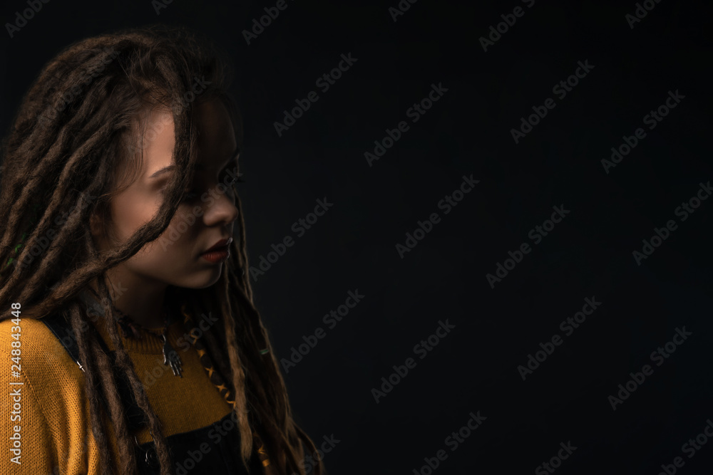 Portrait of a young girl with dreads on black background. Studio shoot. Portrait of a young girl with dreads on black background. Studio shoot.