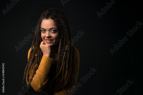 Portrait of a young girl with dreads on black background. Studio shoot.