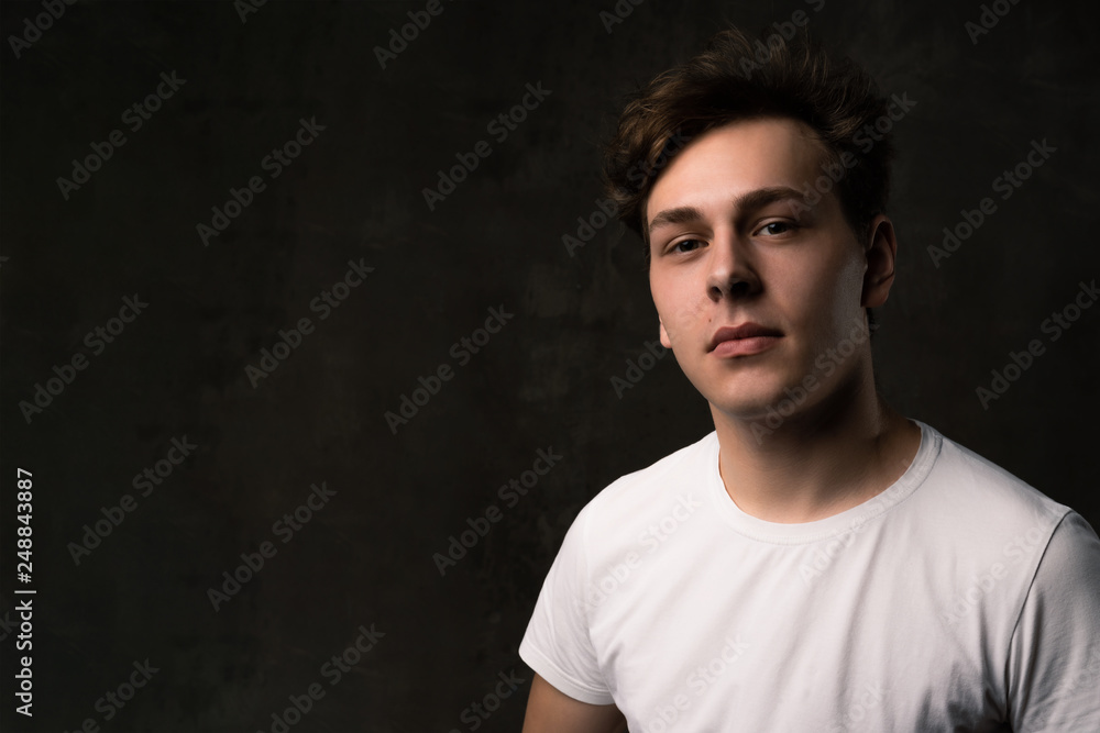 Handsome young man on black background looking at camera.