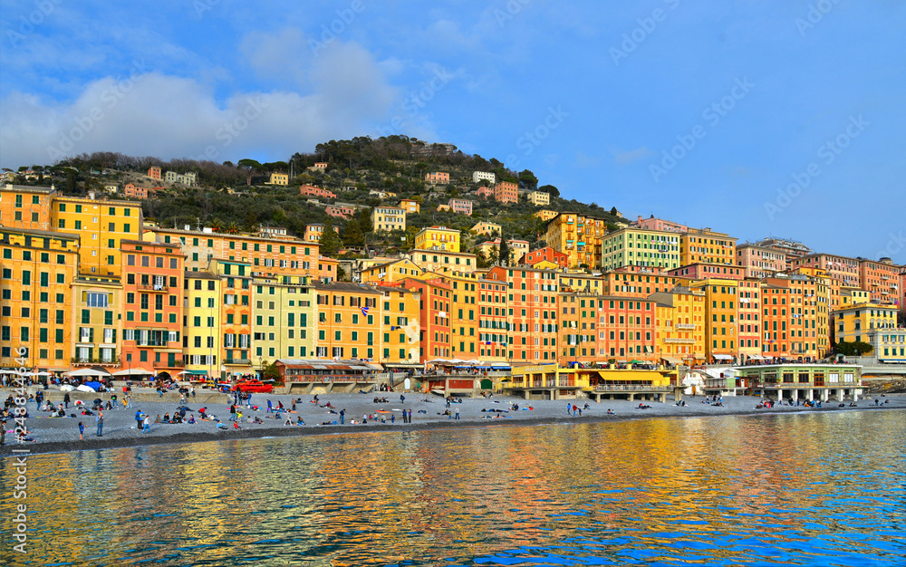 Glimpse of historical Old Town Camogli and sand beach with crowd of people on mediterranean coast in Camogli, italian Riviera, Italy