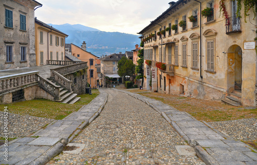 Glimpses of the historical center of Orta San Giulio with people and lake water in background   Lake d Orta   Novara   Piedmont   Italy