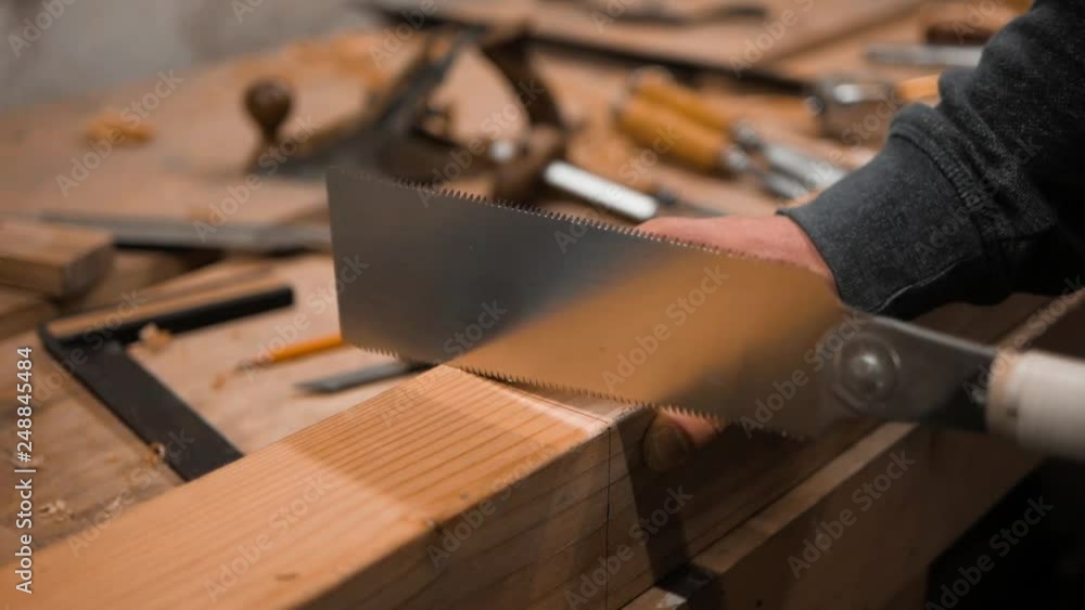 carpenter sawing a wooden blank with a Japanese saw carpenter sawing a wooden blank with a Japanese saw