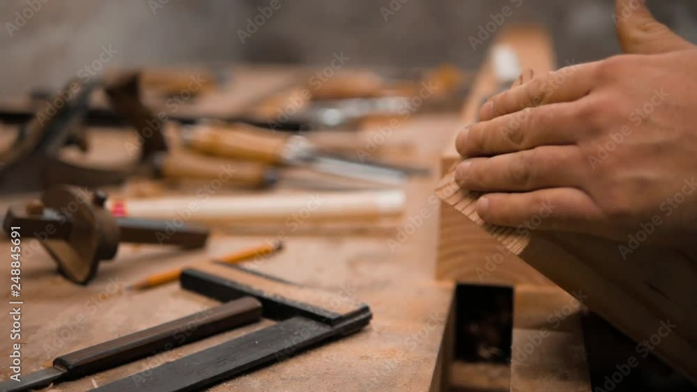 the carpenter checks the surface of the cut with his hand the carpenter checks the surface of the cut with his hand