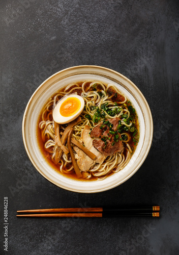 Ramen asian Noodle in broth with Meat and Ajitama pickled Egg in bowl on dark background